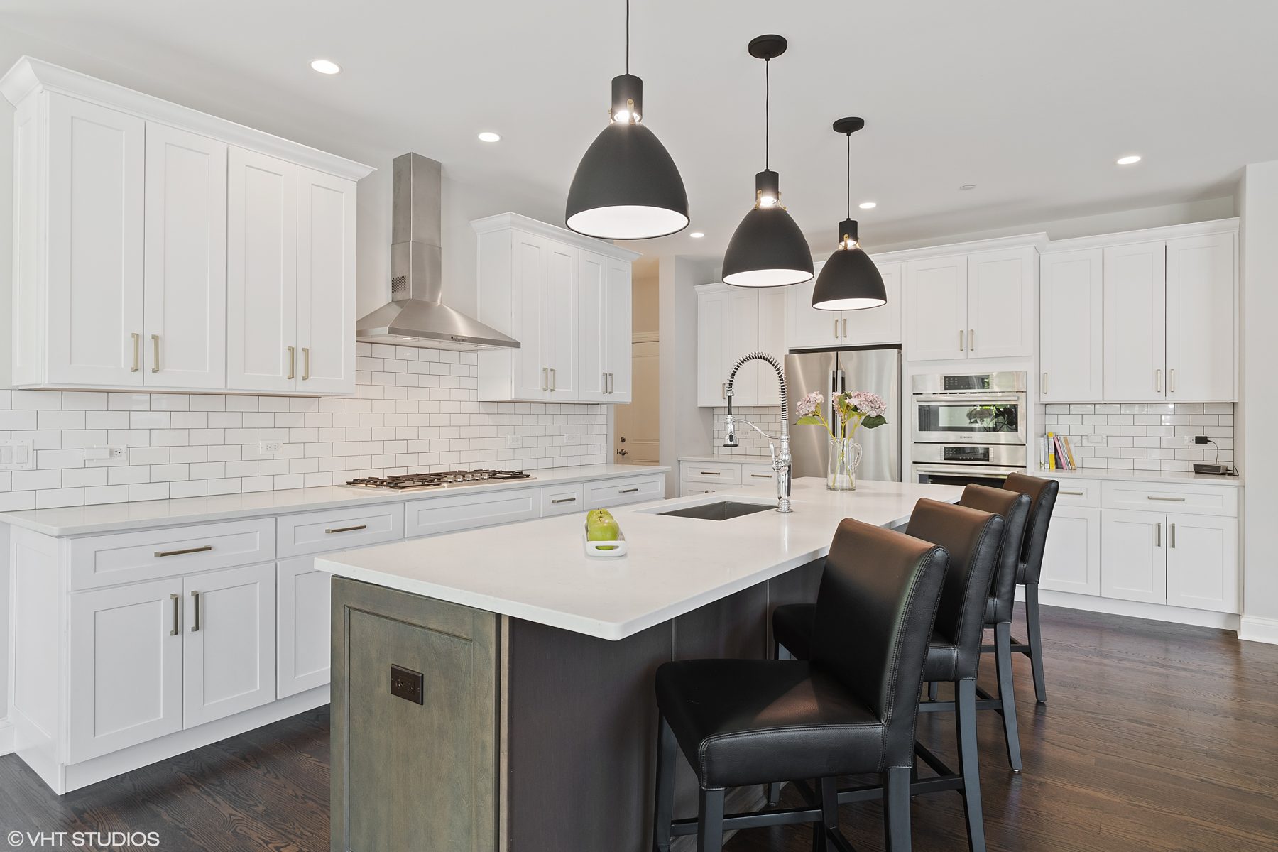 White shaker kitchen with subway tile, black dome pendants and a gray-stained island